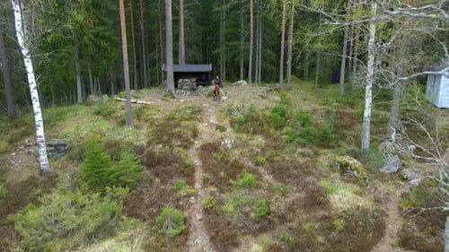 Hiker and Dog at Wind Shelter Cabin in Thick Forest, Aerial Backward