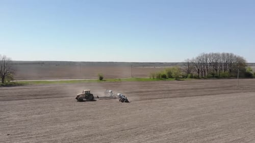 Big yellow tractor planting corn in Ukraine. Tractor working on the field