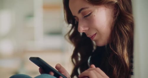 Junge Brünette surft auf dem Smartphone im Internet