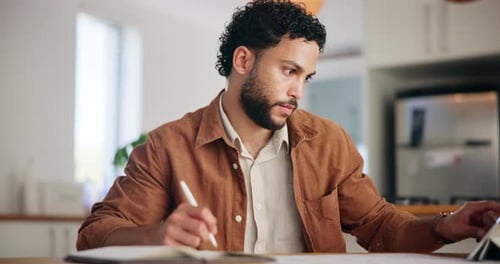 Young Adult Working at Home with Tablet and Journal