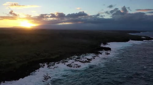 Hawaiian coastline and crashing waves at sunset – aerial view