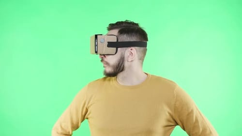 Man in vr glasses shocked by virtual reality experience on green screen