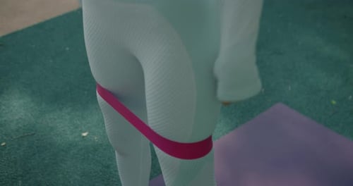 Woman doing Squats with Resistance Band Outdoors