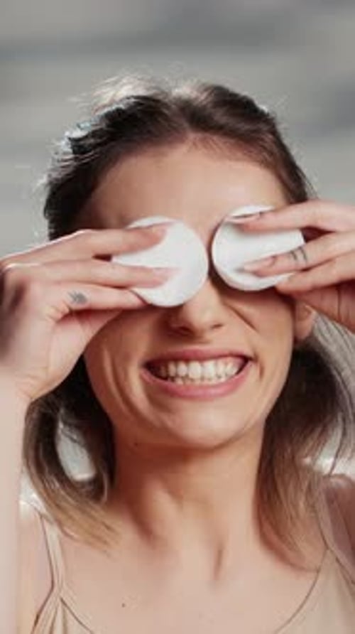Vertical Video Cheerful Beauty Model Playing with Cotton Pads on Camera