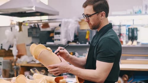 Zeichnet Linien, markiert die Stelle zum Schneiden. Techniker, der im modernen Labor mit Prothesen arbeitet
