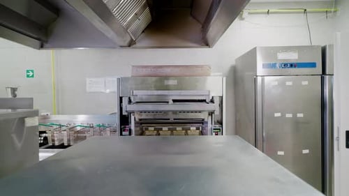 Push-in shot of metallic appliances in fast food restaurant kitchen
