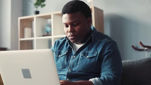Young man works on laptop at his home