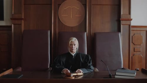 Female Judge Sits in Courtroom with Gavel