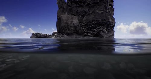 Exploring a Rocky Shoreline Under a Bright Blue Sky By Calm Waters
