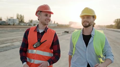 Construction Workers Walking and Talking at Sunset