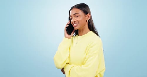 Phone call, speaking or happy Indian woman in studio on blue background for communication or chat