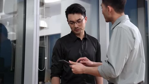 Two Professionals Discussing Tablet in Modern Office