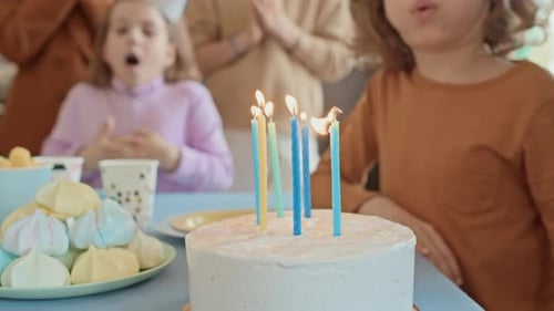 Children Celebrate Birthday at Home Blowing out Candles