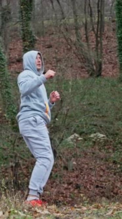 Man Practicing Martial Arts Kicks in Nature