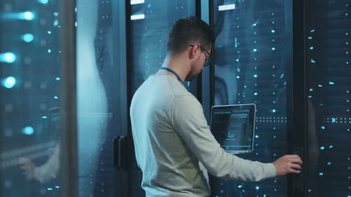 Technician with Laptop in Data Center Server Room