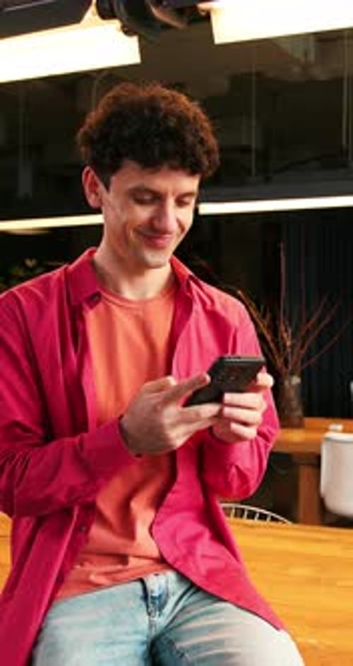 Smiling Happy Positive Man Wearing Stylish Casual Clothes Holding Mobile Phone Using Mobile App