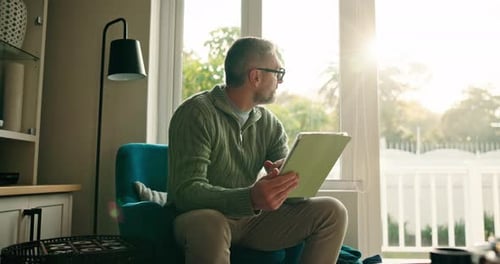 Man Using Tablet in Sunny Living Room