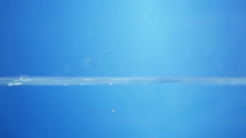 Close-up of water droplets splashing in slow motion, showing purity and transparency in a view of fl