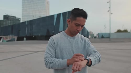 Man Using Smartwatch in Urban Setting