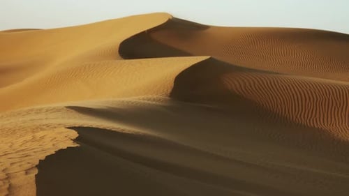 Sand weht im Wind über Sanddünen