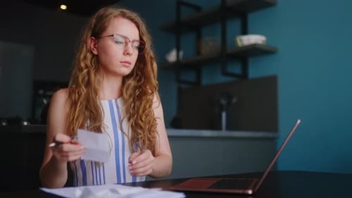 Woman Working at Desk with Laptop and Papers