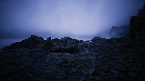 Distant Cliffs and Wet Pebbles Serene Blue Hour Coast with Gentle Waves