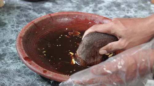 Traditionelle indonesische Sauce namens Sambal Bawang bei der Herstellung mit einem traditionellen Werkzeug namens Ulekan,