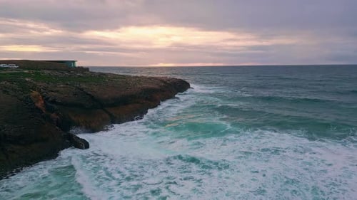 Waves Meeting Rugged Cliffs Under Sunset Sky Dramatic Aerial View Powerful Sea