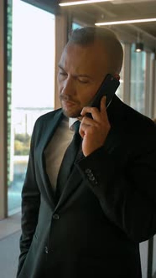 Vertical of Confident Entrepreneur in Office Openspace Calling to His Deal Partner