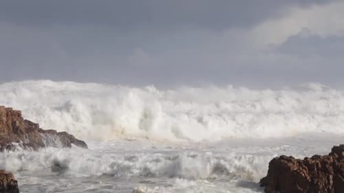 Crashing Waves on Rocky Coastline Under Overcast Sky