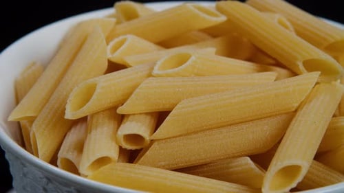 Penne Pasta Closeup Raw Italian Penne Pasta Revolves on a Black Background