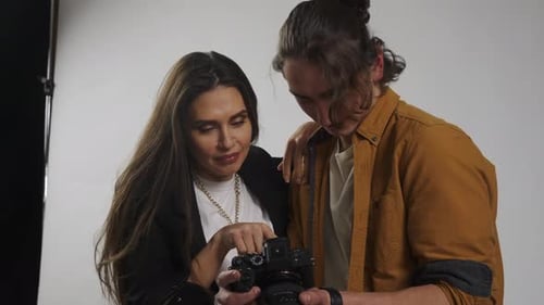 Model and Production Team in the Studio Close Up Photographer and Female Model Checking Pics on