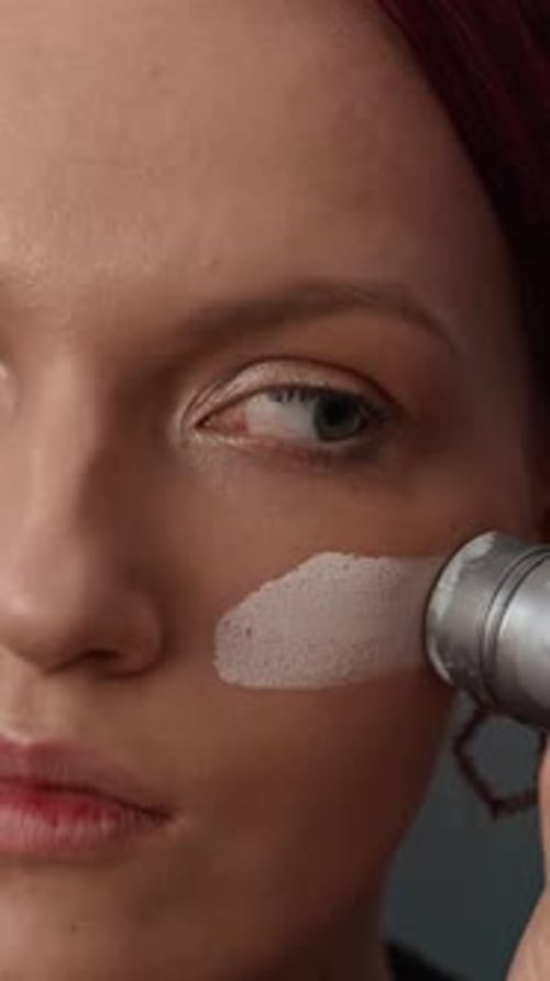 Close-up of Gen Z Girl Applying White Base to Face Skin with Paint Stick