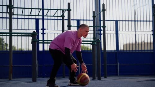 Slowmotion Footage of Basketball Player Dribbling Ball on Outdoor Court