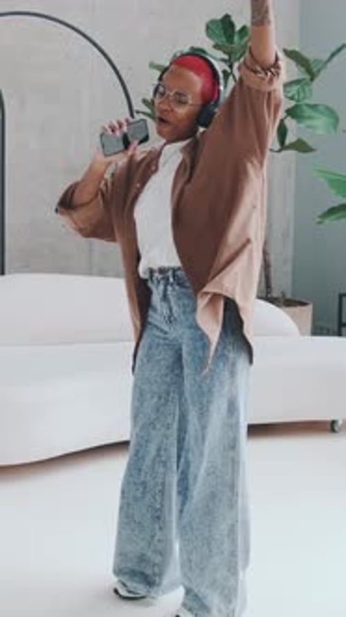 Adult with Red Hair Sings and Dances Indoors