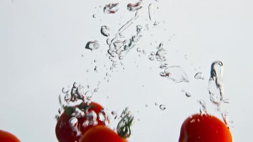 Cherry Tomatoes Falling into Water in Slow Motion