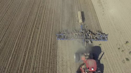 Big red combine working on the field cultivating and applying nitrogen ASP