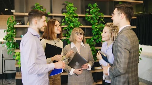 In a Vibrant and Modern Office Space a Diverse Group of Professionals is Deeply Engaged in a