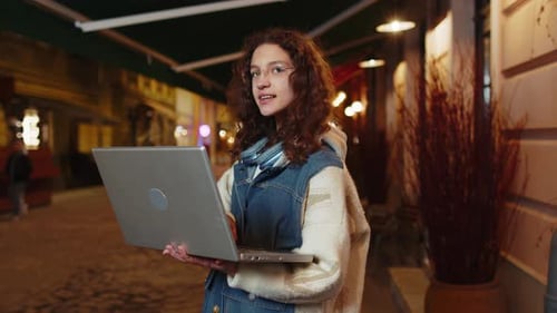 Thoughtful Girl Working Online Distant Job with Laptop in City Street Browsing Website Chatting