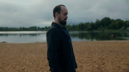 Emotional Man on Beach Holding Letter Overwhelmed By Sadness