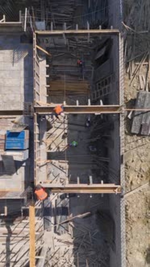 Los ingenieros y trabajadores de vídeo vertical construyen paredes para el siguiente piso de un edificio moderno
