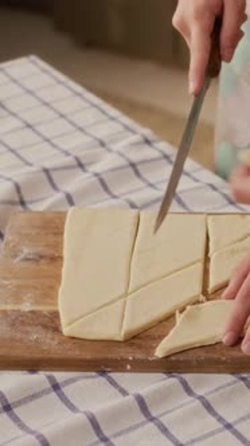 Woman Cutting Dough on Cutting Board with Knife