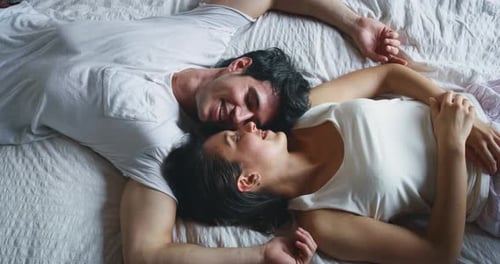 Loving Couple Smiling in Bed Together