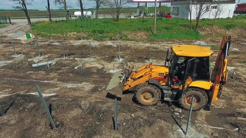 Construction site in progress. Aerial drone view of tractor working at construction site