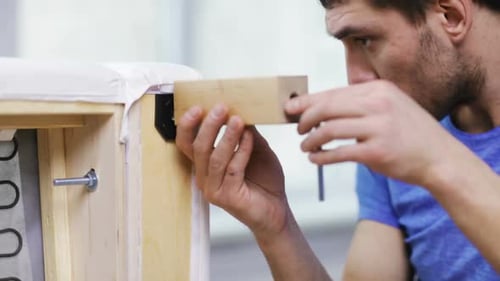 Close up of male hands assembling sofa legs in new home moving to new property