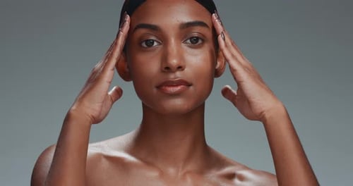 Face, skincare touch and beauty of woman in studio isolated on a gray background