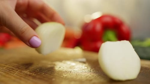 Slicing Onion with Knife on Cutting Board