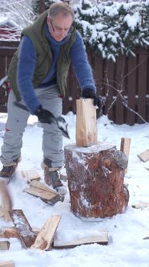 A Middleaged Man is Chopping Firewood