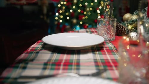 Hands Setting a Festive Christmas Dinner Table