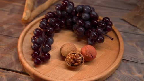 Grapes and Walnuts on a Wooden Board